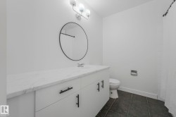 Bathroom featuring vanity, dark tile patterned flooring, and a shower with shower curtain - 