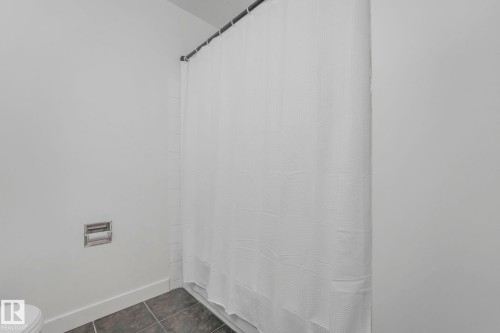 Bathroom with dark tile patterned flooring and a shower with curtain - 5833 Riverbend Road, Edmonton, AB - Indoor