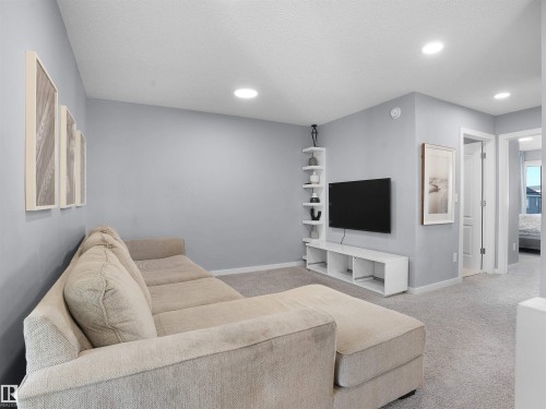 Living area featuring light carpet, recessed lighting, and a textured ceiling - 207 41 Avenue, Edmonton, AB - Indoor