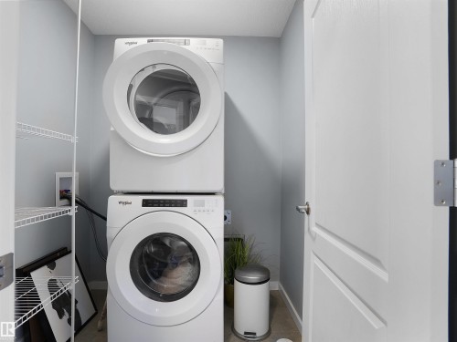 Laundry area with stacked washer and clothes dryer and baseboards - 207 41 Avenue, Edmonton, AB - Indoor Photo Showing Laundry Room