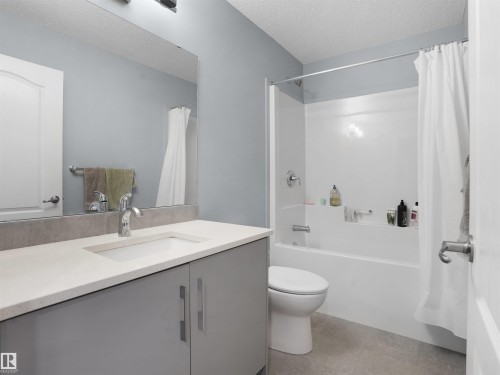 Bathroom featuring vanity, a textured ceiling, and shower / bathtub combination with curtain - 207 41 Avenue, Edmonton, AB - Indoor Photo Showing Bathroom