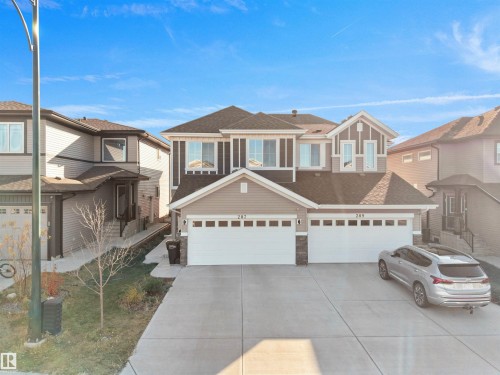 View of front of property featuring a shingled roof, driveway, stone siding, and a garage - 207 41 Avenue, Edmonton, AB - Outdoor With Facade