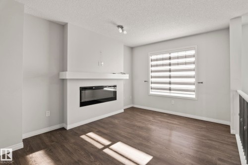 #62 4050 Savaryn Drive Sw, Edmonton, AB - Indoor Photo Showing Living Room With Fireplace