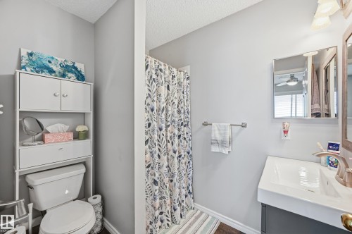 Full bath with a shower with shower curtain, vanity, a textured ceiling, and ceiling fan - 2952 39 Avenue, Edmonton, AB - Indoor Photo Showing Bathroom