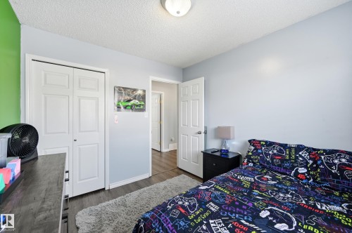 Bedroom with a textured ceiling, dark wood-style floors, and a closet - 2952 39 Avenue, Edmonton, AB - Indoor Photo Showing Bedroom
