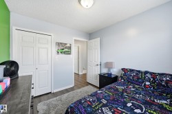 Bedroom with a textured ceiling, dark wood-style floors, and a closet - 