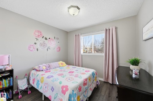 Bedroom featuring dark wood-type flooring and a textured ceiling - 2952 39 Avenue, Edmonton, AB - Indoor Photo Showing Bedroom