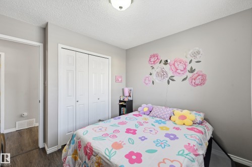 Bedroom with a textured ceiling, a closet, and dark wood finished floors - 2952 39 Avenue, Edmonton, AB - Indoor Photo Showing Bedroom