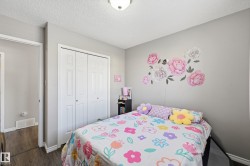 Bedroom with a textured ceiling, a closet, and dark wood finished floors - 