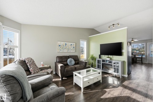 Living room featuring wood finished floors, plenty of natural light, a ceiling fan, and track lighting - 2952 39 Avenue, Edmonton, AB - Indoor Photo Showing Living Room