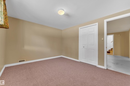 Carpeted empty room with baseboards and stairs - 20920 9 Avenue, Edmonton, AB - Indoor Photo Showing Other Room