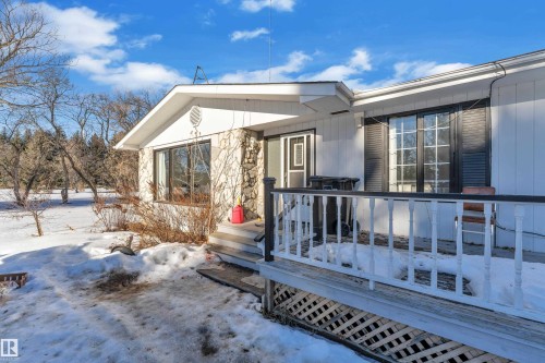 Snow covered property entrance with a wooden deck - 20920 9 Avenue, Edmonton, AB - Outdoor