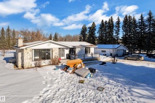 View of front of property with a wooden deck, a chimney, and stone siding - 20920 9 Avenue, Edmonton, AB - Outdoor With Deck Patio Veranda