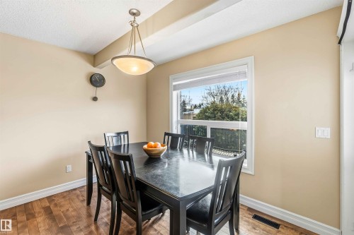 Dining space featuring hardwood / wood-style flooring, beam ceiling, and a textured ceiling - 11715 167A Avenue, Edmonton, AB - Indoor Photo Showing Dining Room