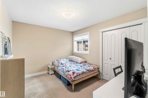 Bedroom featuring light carpet, a closet, and a textured ceiling - 11715 167A Avenue, Edmonton, AB - Indoor Photo Showing Bedroom