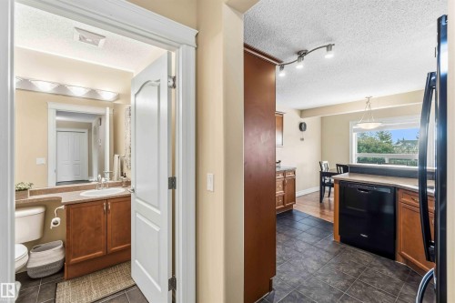 Bathroom with a textured ceiling, vanity, and dark tile patterned floors - 11715 167A Avenue, Edmonton, AB - Indoor Photo Showing Bathroom