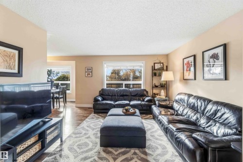 Living area featuring a textured ceiling, wood finished floors, and healthy amount of natural light - 11715 167A Avenue, Edmonton, AB - Indoor Photo Showing Living Room