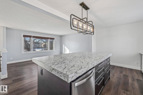Kitchen with light countertops, a center island, hanging light fixtures, and stainless steel dishwasher - 14911 96 Street, Edmonton, AB - Indoor Photo Showing Kitchen With Upgraded Kitchen
