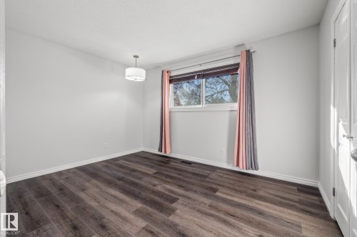 Empty room with dark wood-style floors and baseboards - 14911 96 Street, Edmonton, AB - Indoor Photo Showing Other Room