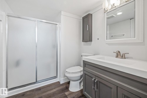Full bath with a stall shower, vanity, and dark wood-type flooring - 14911 96 Street, Edmonton, AB - Indoor Photo Showing Bathroom