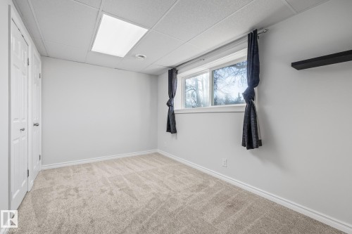 Unfurnished bedroom featuring a drop ceiling and light carpet - 14911 96 Street, Edmonton, AB - Indoor Photo Showing Other Room