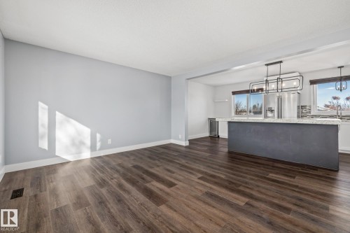 Unfurnished living room with dark wood-style flooring and a chandelier - 14911 96 Street, Edmonton, AB - Indoor