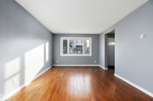 Spare room featuring hardwood / wood-style floors and a textured ceiling - 15C Callingwood Crest, Edmonton, AB - Indoor Photo Showing Other Room