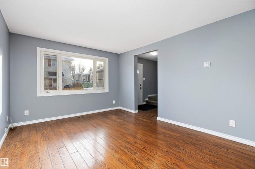Empty room with baseboards and dark wood-style flooring - 15C Callingwood Crest, Edmonton, AB - Indoor
