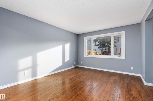 Empty room with baseboards and hardwood / wood-style flooring - 15C Callingwood Crest, Edmonton, AB - Indoor Photo Showing Other Room