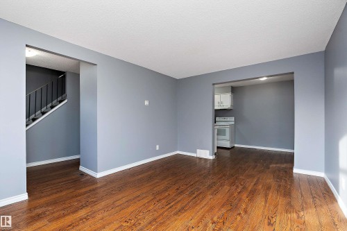 Unfurnished living room with dark wood-type flooring and a textured ceiling - 15C Callingwood Crest, Edmonton, AB - Indoor Photo Showing Other Room