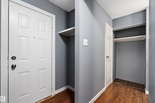 Mudroom with a textured ceiling and dark wood-style flooring - 15C Callingwood Crest, Edmonton, AB - Indoor Photo Showing Other Room