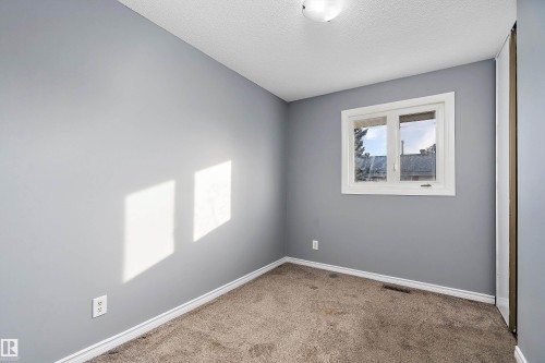 Empty room with carpet flooring and a textured ceiling - 15C Callingwood Crest, Edmonton, AB - Indoor Photo Showing Other Room
