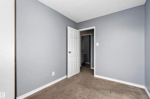 Unfurnished bedroom featuring carpet flooring and a textured ceiling - 15C Callingwood Crest, Edmonton, AB - Indoor Photo Showing Other Room