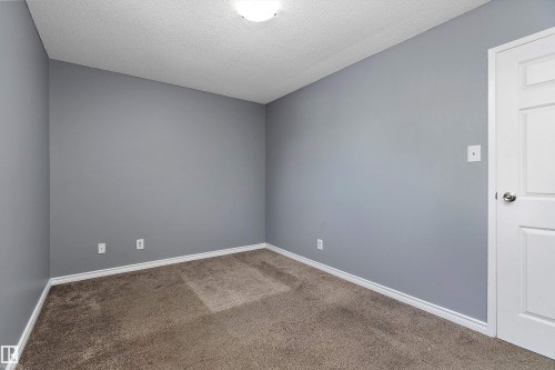 Carpeted spare room with baseboards and a textured ceiling - 15C Callingwood Crest, Edmonton, AB - Indoor Photo Showing Other Room