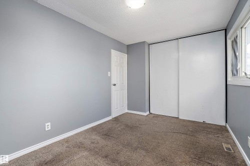 Unfurnished bedroom featuring carpet, a closet, and a textured ceiling - 15C Callingwood Crest, Edmonton, AB - Indoor Photo Showing Other Room