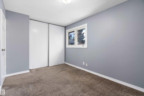 Unfurnished bedroom featuring carpet floors, a textured ceiling, and a closet - 15C Callingwood Crest, Edmonton, AB - Indoor Photo Showing Other Room
