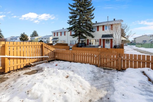 Snow covered property with a fenced backyard, a residential view, and a gate - 15C Callingwood Crest, Edmonton, AB - Outdoor