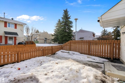 Yard layered in snow with a fenced backyard and a residential view - 15C Callingwood Crest, Edmonton, AB - Outdoor