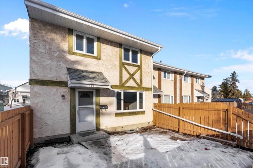 Back of property with a fenced backyard and stucco siding - 15C Callingwood Crest, Edmonton, AB - Outdoor With Exterior