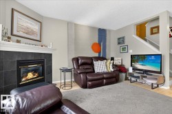 Living area featuring a textured ceiling, a tiled fireplace, and wood finished floors - 