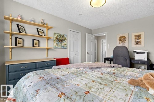 Carpeted bedroom with a textured ceiling and a closet - 23 4020 21 Street, Edmonton, AB - Indoor Photo Showing Bedroom