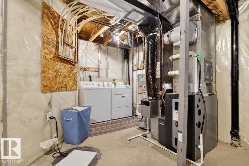Unfinished below grade area featuring washing machine and dryer, heating unit, and gas water heater - 23 4020 21 Street, Edmonton, AB - Indoor Photo Showing Laundry Room