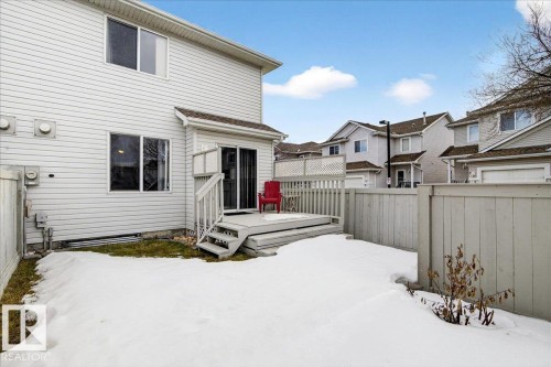 Snow covered property with a fenced backyard, a deck, and a residential view - 23 4020 21 Street, Edmonton, AB - Outdoor With Exterior