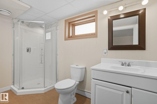 Bathroom featuring vanity, a shower stall, light tile patterned flooring, and a drop ceiling - 11222 71 Avenue, Edmonton, AB - Indoor Photo Showing Bathroom
