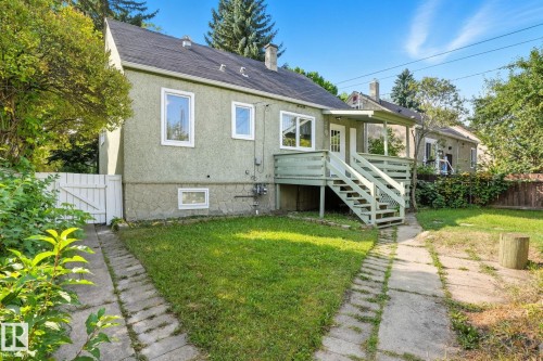 Rear view of property featuring a chimney, a shingled roof, stucco siding, a gate, and stairs - 11222 71 Avenue, Edmonton, AB - Outdoor