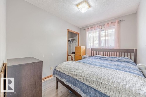 Bedroom with a closet, a textured ceiling, and wood finished floors - 12253 95A Street, Edmonton, AB - Indoor Photo Showing Bedroom