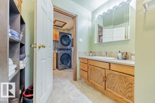 Bathroom with vanity and estacked washer and dryer - 12253 95A Street, Edmonton, AB - Indoor Photo Showing Bathroom