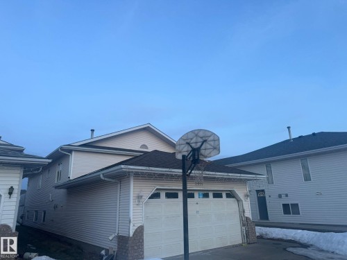 View of side of property with a garage, roof with shingles, and driveway - 3011 37 Street Nw, Edmonton, AB - Outdoor