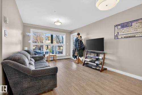Living area featuring light wood finished floors and baseboards - 104 8515 99 Street, Edmonton, AB - Indoor