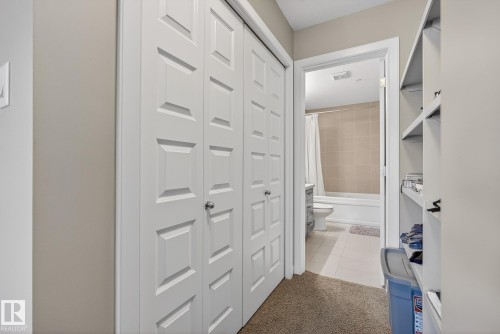 Hallway with light tile patterned floors and light colored carpet - 104 8515 99 Street, Edmonton, AB - Indoor